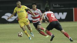 Striker Bhayangkara FC, Thiago Furtuoso, berusaha melwati bek Madura United, Asep Berlian pada laga lanjutan liga 1 di Stadion Patriot, Bekasi, kamis (13/7/2017). Bhayangkara FC menang 2-1 atas Madura United. (Bola.com/M Iqbal Ichsan)