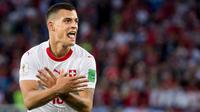 Pemain Swiss, Granit Xhaka merayakan gol ke gawang Serbia pada laga grup E Piala Dunia 2018 di Stadion Kaliningrad, Jumat (22/6). Xhaka merayakan gol dengan gerakan tangan seperti lambang burung di bendera Albania. (Laurent Gillieron/Keystone via AP)