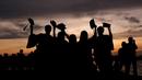 Siswa yang mengenakan gaun kelulusan mereka berpose untuk foto saat matahari terbenam di Victoria Harbour, Hong Kong, Selasa (30/6/2020). (AP Photo/Kin Cheung)