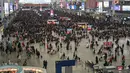 Penumpang menunggu jadwal keberangkatan mereka di Stasiun Kereta Hongqiao di Shanghai pada Senin (20/1/2020). China berada di tengah-tengah kesibukan migrasi manusia tahunan ketika jutaan orang pulang ke kampung halaman mereka untuk menikmati libur Tahun Baru Imlek. (HECTOR RETAMAL/AFP)