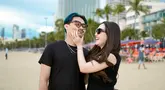 Latar belakang pantai dengan hamparan pasir putih memperlihatkan momen santai keduanya di tengah kesibukan untuk manggung. Potret tersebut menunjukkan sisi lain dari Happy Asmara yang biasanya terlihat di atas panggung, kali ini ia menikmati momen indah bersama orang yang dicintainya. (Liputan6.com/IG/@happy_asmara77)