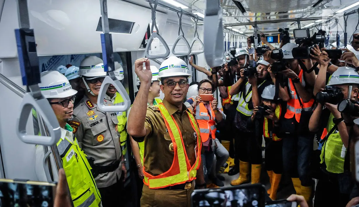 Gubernur DKI Jakarta Anies Baswedan saat mencoba Moda Raya Terpadu (MRT) dari Stasiun Bundaran HI-Lebak Bulus, Jakarta, Senin (10/12). Anies terlihat banyak tersenyum selama perjalanan. (Liputan6.com/Faizal Fanani)