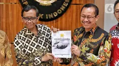 Menteri Koordinator Bidang Politik, Hukum, dan Keamanan (Menko Polhukam) Mahfud MD (kiri) menerima berkas laporan terkait investigasi tragedi Kanjuruhan dari Ketua Komnas HAM Ahmad Taufan Damanik (kanan) di Kantor Menko Polhukam, Jakarta, Kamis (3/11/2022). Menko Polhukam mewakili Presiden Joko Widodo atau Jokowi menerima laporan terkait investigasi tragedi Kanjuruhan yang berisi rekomendasi untuk membekukan seluruh kegiatan PSSI. (Liputan6.com/Angga Yuniar)