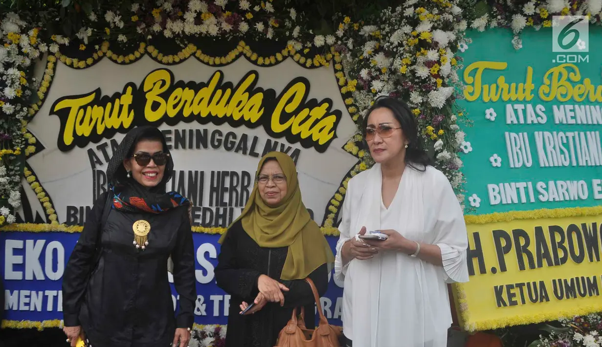 Warga berdiri di depan karangan bunga sekitar tempat persemayaman Ani Yudhoyono di Puri Cikeas, Bogor, Jawa Barat, Minggu (2/6/2019). Ani Yudhoyono akan dimakamkan di samping pusara istri presiden ke-3 RI BJ Habibie, Ainun Habibie.(Liputan6.com/Immanuel Antonius)