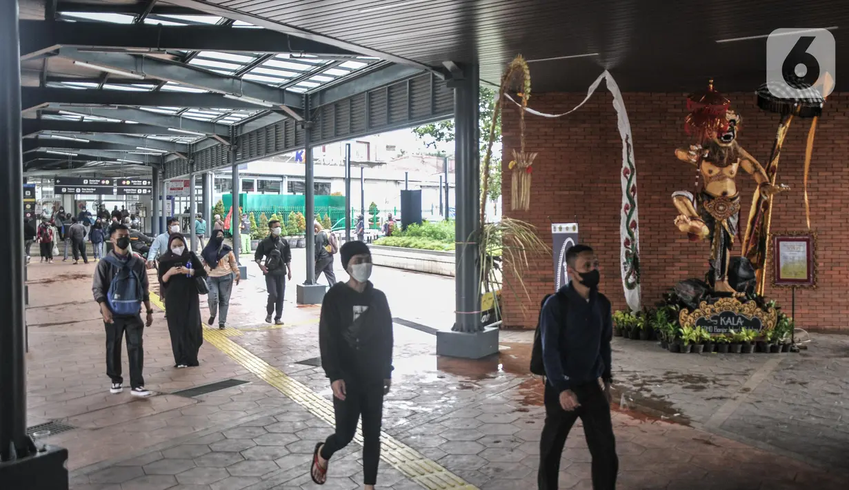 Penumpang Commuter Line atau KRL melintasi patung Ogoh-Ogoh yang dipajang di Stasiun Tebet, Jakarta Selatan, Selasa (1/3/2022). Patung Ogoh-Ogoh tersebut dipajang dalam rangka menyambut Hari Raya Nyepi Tahun Baru Saka 1944 yang jatuh pada 3 Maret mendatang. (merdeka.com/Iqbal S. Nugroho)
