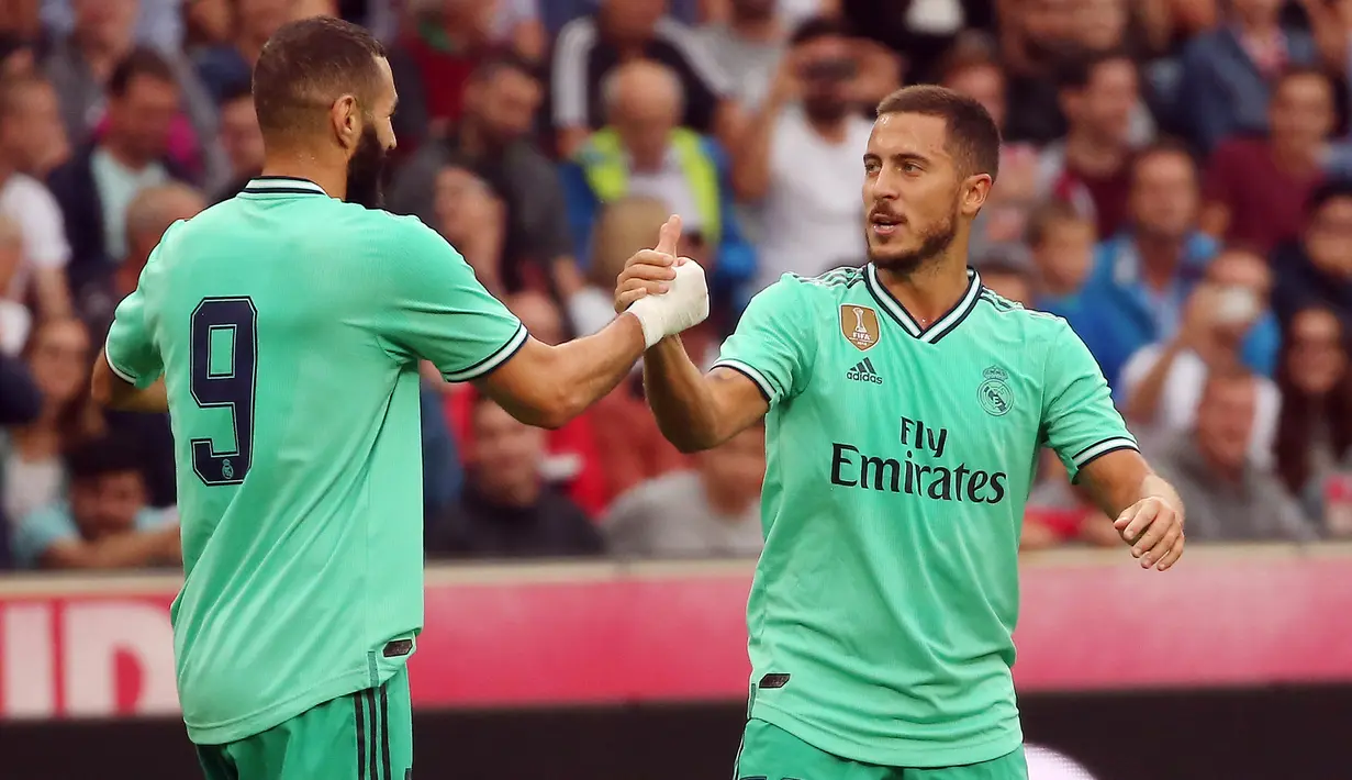 Gelandang Real Madrid, Eden Hazard berselebrasi dengan rekannya Karim Benzema setelah mencetak gol ke gawang Red Bull Salzburg pada laga persahabatan di Red Bull Arena, Austria (8/8/2019). Winger asal Belgia itu mencetak gol perdananya untuk klub barunya Real Madrid. (AFP Photo/Krugfoto)