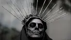 Seorang wanita mengenakan kostum tengkorak menunggu dimulainya Prosesi Grand Catrinas, untuk menandai perayaan Day of The Dead, di Mexico City, Minggu (22/10). Dalam prosesi tersebut warga berdandan menyerupai kerangka. (AP/Rebecca Blackwell)