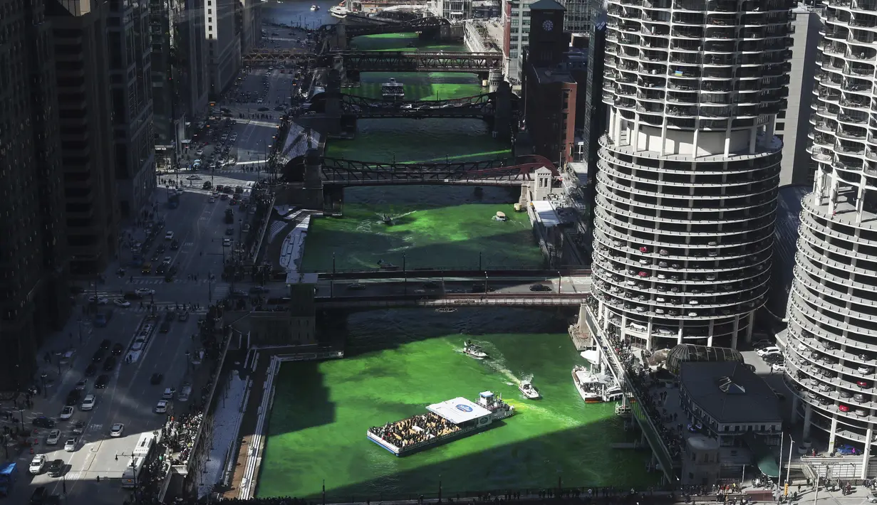Pewarnaan Sungai Chicago dimulai, terlihat dari ballroom penthouse lantai 39 di hotel Royal Sonesta, Chicago, Sabtu (12/3/2022). Perubahan warna ini dilakukan untuk menyambut Hari St. Patrick pada Kamis mendatang.  (John J. Kim/Chicago Tribune via AP)