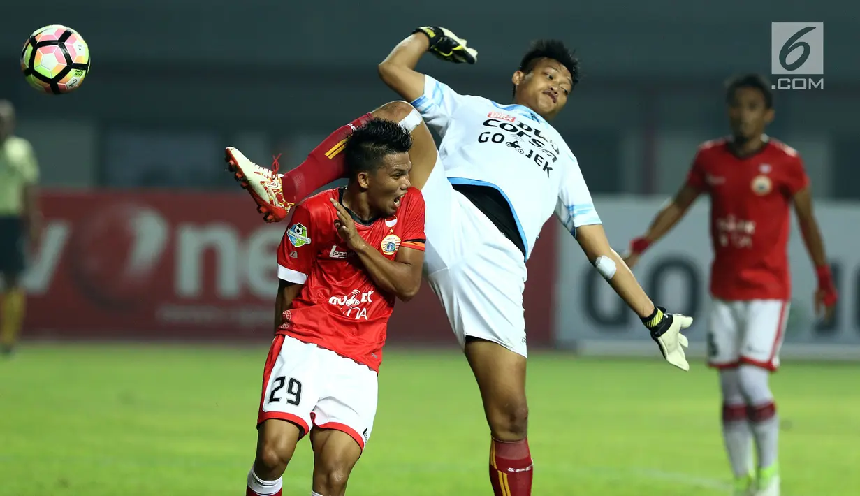 Kiper Arema FC, Kurnia Meiga Hermansyah (tengah) berduel dengan pemain Persija Sandi Sute saat laga lanjutan Liga 1 Indonesia di Stadion Patriot Candrabhaga, Bekasi, Jumat (2/6). Persija unggul 2-0 atas Arema FC. (Liputan6.com/Helmi Fithriansyah)
