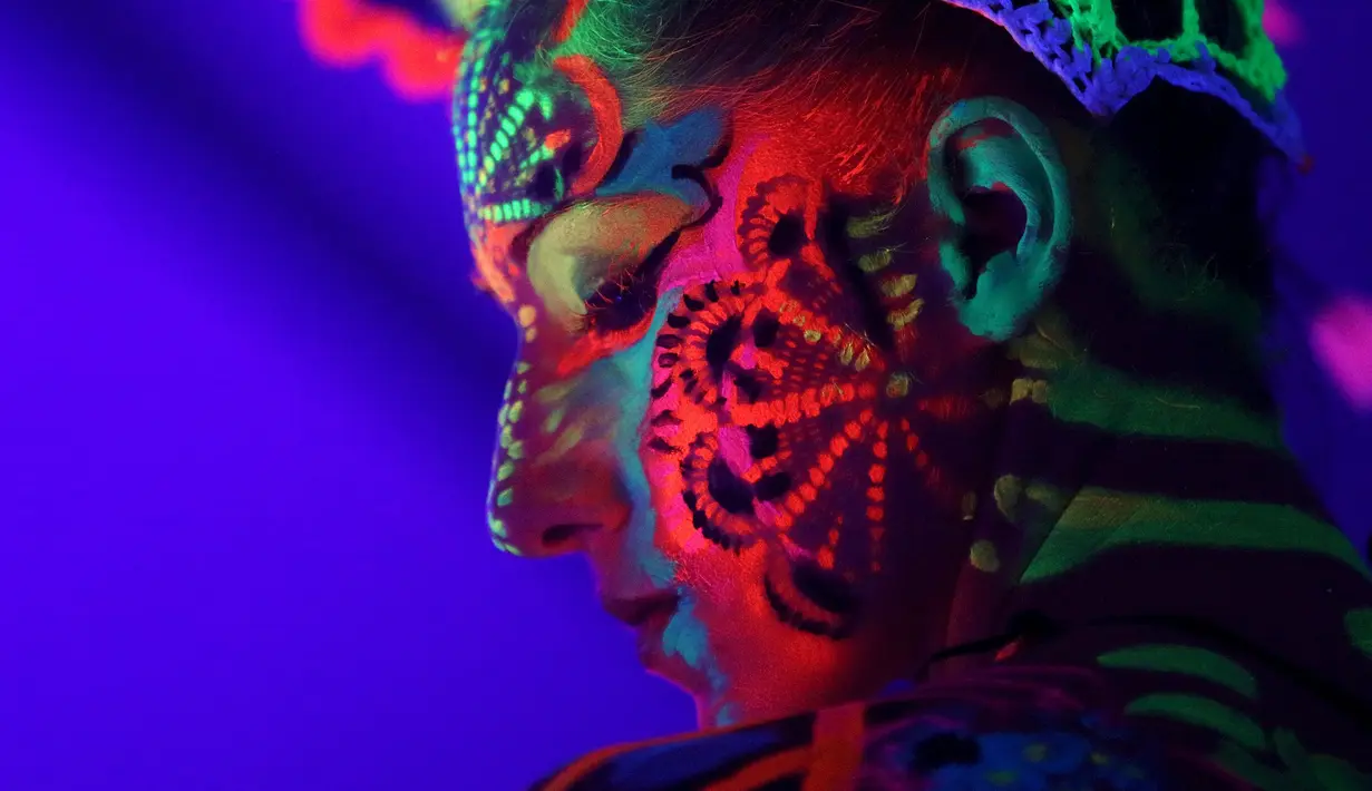Model menunjukkan lukisan ultraviolet di muka saat mengikuti Festival Bodypainting Dunia 2015 di Poertschach, Austria, (3/7/2015). Festival ini menampilkan beragam motif lukisan unik hasil karya para seniman terkemuka dunia. (Reuters/Heinz-Peter Bade)