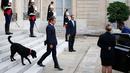 Presiden Prancis Emmanuel Macron bersama anjingnya bernama Nemo saat menyambut tamu di Istana Elyses, Paris, Prancis (28/8). Nemo adalah anjing Labrador salah satu dari beberapa jenis anjing pemungut buruan. (AP Photo / Francois Mori)