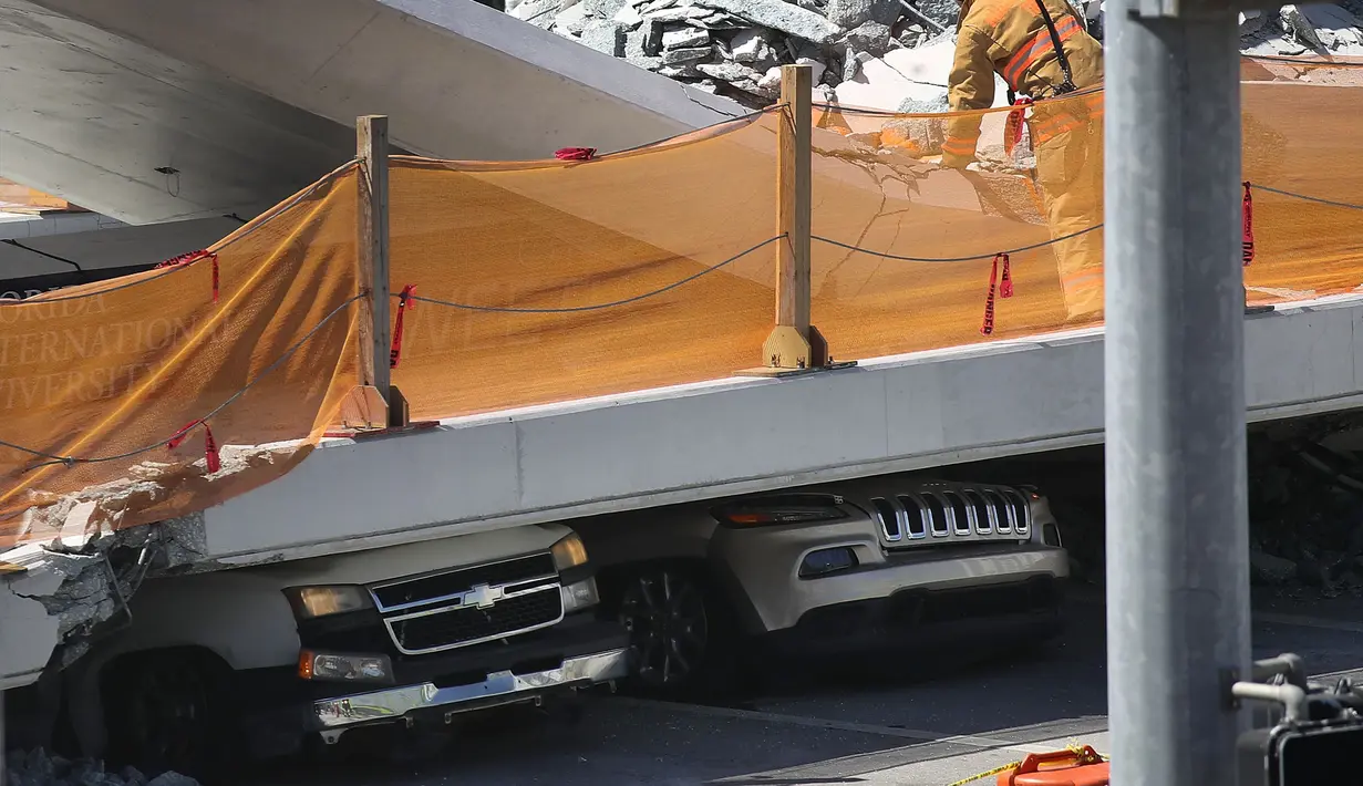 Sejumlah mobil hancur akibat tertimpa jembatan pejalan kaki yang runtuh di Miami, Florida (15/3). Sedikitnya delapan mobil terjebak dalam reruntuhan jembatan. (Joe Raedle/Getty Images/AFP)