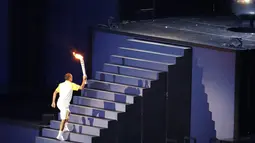 Vanderlei Cordeiro de Lima membawa obor olimpiade di Stadion Maracana di Rio de Janeiro, Brasil, (5/8). de Lima mendapat kehormatan untuk menyalakan kawah raksasa tersebut dari obor yang telah diarak keliling dunia. (AFP PHOTO/Fabrice COFFRINI)