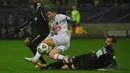 Gelandang Paris Saint-Germain (PSG) Ismael Gharbi (tengah) ditekel oleh pemain klub divisi empat, Vannes OC dalam babak 32 besar Piala Prancis di Stade de la Rabine, Selasa (4/1/2021) dini hari WIB. PSG menang 4-0 lewat hattrick Kylian Mbappe. (LOIC VENANCE/AFP)