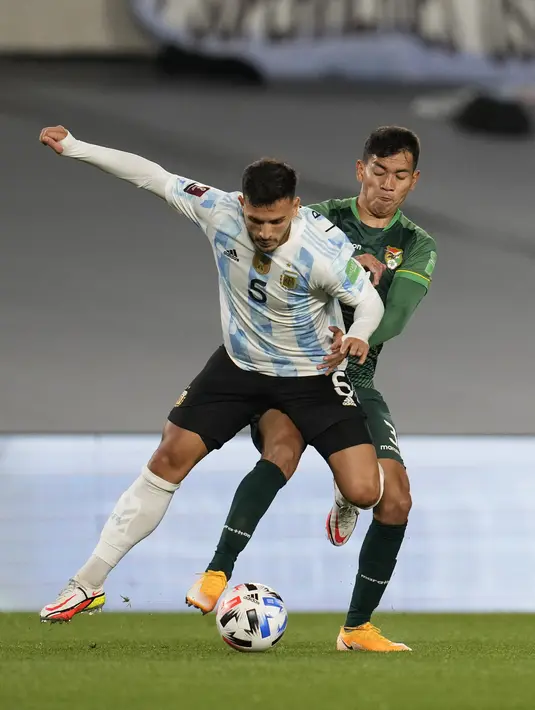 Gelandang Argentina, Leandro Paredes berebut bola dengan bek Bolivia, Jesus Sagredo pada Kualifikasi Piala Dunia 2022 zona Amerika Selatan, di Stadion El Monumentttal, Jumat (10/9/2021). Hat-trick Lionel Messi membuat Argentina menang 3-0 atas Bolivia. (Natacha Pisarenko/POOL/AFP)