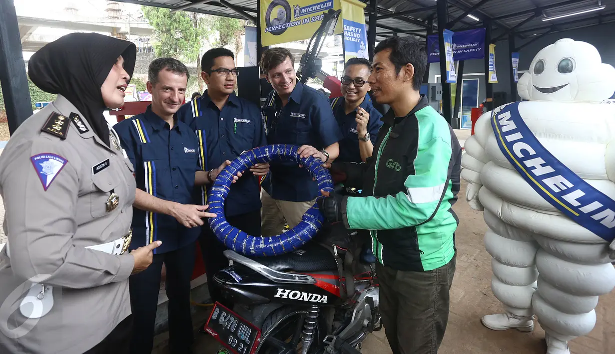 Presdir. PT Michelin Indonesia Pascal Nouvellon (ketiga kanan) dan Kasubdit Dikyasa Ditlantas Polda Metro Jaya AKBP Agustin Susilowati menunjukkan produk ban roda dua Michelin kepada pengendara, di Jakarta, Rabu (15/6). (Liputan6.com/Angga Yuniar)