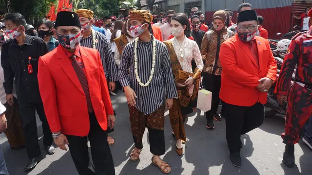 Calon Wali Kota-Wakil Wali Kota yang diusung PDIP Gibran Rakabuming Raka dan istrinya saat mendaftar ke KPU, Jumat (4/9/2020). (Liputan6.com/Fajar Abrori)