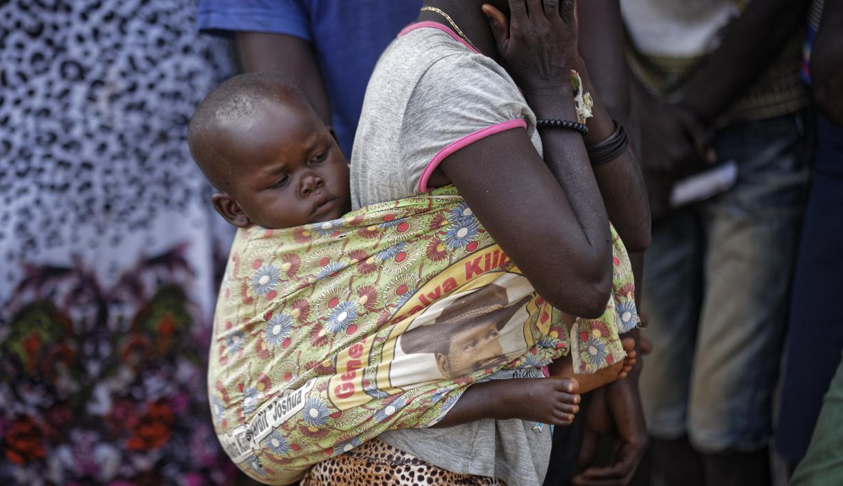 Pengungsi Sudan Selatan menggendong anaknya di sebuah pusat transit pengungsi di Kuluba, Uganda utara, Kamis (8/6). Mereka melarikan diri dari perang saudara di Sudan Selatan yang telah memakan korban puluhan ribu jiwa. (AP Photo / Ben Curtis)