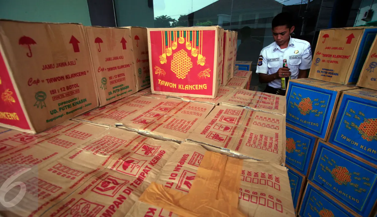 Petugas bediri di dekat sejumlah kardus berisi jamu di kantor BPOM Yogyakarta, Rabu (30/3/2016). BPOM Yogyakarta berhasil mengamankan 1.800 kardus jamu tradisional tanpa izin edar. (Foto: Boy Harjanto)