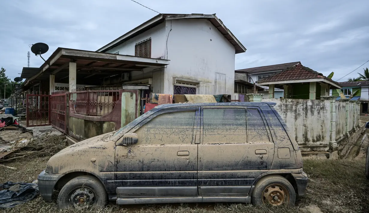 Sebuah mobil terlihat di luar rumah setelah banjir surut di Mentakab, negara bagian Pahang, Malaysia (11/1/2020).  Pahang menjadi negara bagian di Malaysia yang paling parah terkena dampak banjir, di mana lebih dari 21.000 warga telah dievakuasi dalam beberapa hari terakhir.  (AFP/Mohd Rasfan)