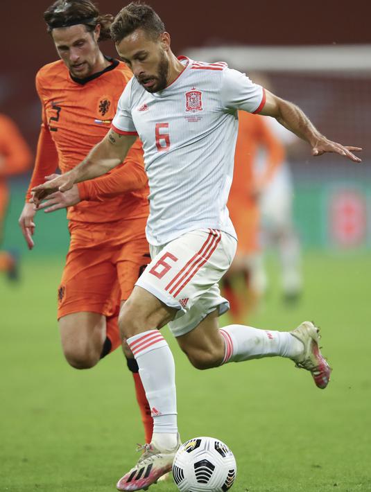 Bek Belanda, Hans Hateboer berebut bola dengan gelandang Spanyol, Sergio Canales dalam laga persahabatan internasional di Johan Cruijff ArenA, Amsterdam, Kamis dinihari WIB (12/11/2020). Kedua tim bermain sama kuat 1-1. (Dean Mouhtaropoulos/Pool via AP)