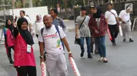 Volunteer Asian Para Games 2018 membantu suporter menunjukkan lokasi pintu masuk di Stadion GBK, Jakarta, Kamis (11/10). Mereka bertugas membantu kelancaran pelaksanaan Asian Para Games 2018. (Liputan6.com/Helmi Fithriansyah)
