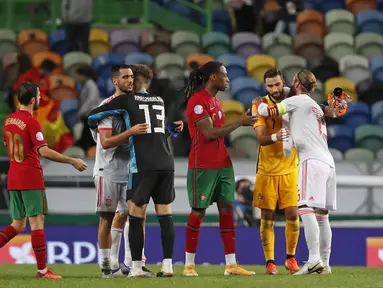 Para pemain berpelukan usai pertandingan persahabatan internasional antara Portugal dan Spanyol di stadion Jose Alvalade di Lisbon, Rabu (7/10/2020). Spanyol bermain imbang 0-0 atas Portugal. (AP Photo/Armando Franca)