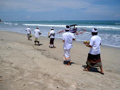 Umat Hindu menghadiri upacara Melasti menjelang Hari Raya Nyepi Tahun Baru Saka 1943 di Pantai Kuta, Bali (11/3/2021). Ritual Melasti untuk menyucikan alam agar Hari Raya Nyepi dapat berjalan  hening serta damai.(AFP/Sonny Tumbelaka)
