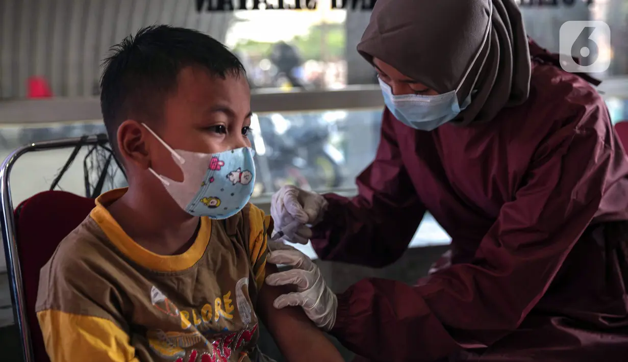 Petugas kesehatan menyuntikkan vaksin COVID-19 Sinovac kepada anak di Pospol Polsek Pamulang, Tangerang Selatan, Banten, Kamis (6/1/2022). Target vaksinasi bertujuan mendukung pembelajaran tatap muka (PTM) yang mulai dilaksanakan 100 persen pada pekan ini. (Liputan6.com/Faizal Fanani)