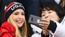 Putri Presiden AS Donald Trump, Ivanka Trump (kiri) berpose dengan istri Presiden Korea Moon Jae-in, Kim Jung-sook (kanan) saat menonton snowboard pria pada Olimpiade Musim Dingin Pyeongchang 2018, Korea Selatan, Sabtu (24/2). (FRANCK FIFE/AFP)