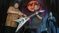 CEO Rajawali Indonesia Communication, Anas Syahrul Alimi (kanan) menyerahkan gitar bertanda tangan personel Megadeth kepada pemenang lelang, yang diwakil Edy Gun, di Hard Rock Cafe, Jakarta, Jumat (30/11). (New Fimela/Bambang Eros)