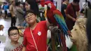 Dua orang anak bermain bersama burung Kakak Tua saat gelaran Jakarta Indonesia Pet Show 2019 di JIExpo Kemayoran, Jakarta, Sabtu (23/2). Pameran khusus hewan kesayangan/hobi ini berlangsung hingga Minggu (24/2). (Liputan6.com/Helmi Fithriansyah)