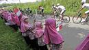 Anak-anak sekolah Dharmasraya memberikan semangat untuk para pebalap saat Tour de Singkarak 2016 dari Sinjunjung menuju Dharmasraya, Sumatera Barat, Jumat (12/8/2016). (Bola.com/Nicklas Hanoatubun)