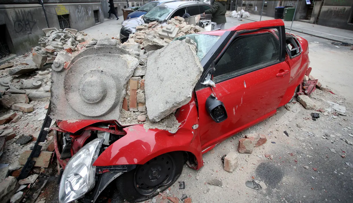 Kondisi sebuah mobil yang hancur tertimpa reruntuhan bangunan setelah guncangan gempa di pusat kota Zagreb, Korasia (22/3/2020). Setelah gempa hari Minggu, wali kota Zagreb mendesak orang-orang untuk kembali ke rumah karena khawatir tentang Virus Corona COVID-19. (AFP/Damir Sencar)