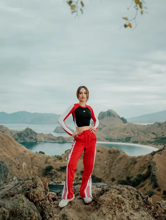 Liburan di Labuan Bajo, Cinta Laura pilih outfit bergaya sporty. Ia memadukan long sleeve crop top dan sweatpants merah [@cintalaura]