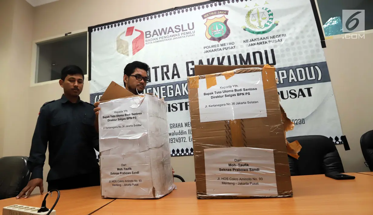 Petugas Bawaslu Jakarta Pusat menunjukkan kardus berisi form C1 Pemilu yang diamankan di Gedung Bawaslu Jakarta Pusat, Senin (6/5/2019). Pihak Bawaslu mengatakan masih akan melakukan investigasi dan pemeriksaan terhadap temuan form C1 dari sejumlah daerah itu. (Liputan6.com/Helmi Fithriansyah)