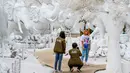 Foto pada yang diabadikan 2 September 2020 memperlihatkan pengunjung berfoto di depan patung dari pasir putih yang menyerupai es di taman "Frost Magical Ice of Siam", di luar Pattaya, Thailand. (Photo by Mladen ANTONOV / AFP)