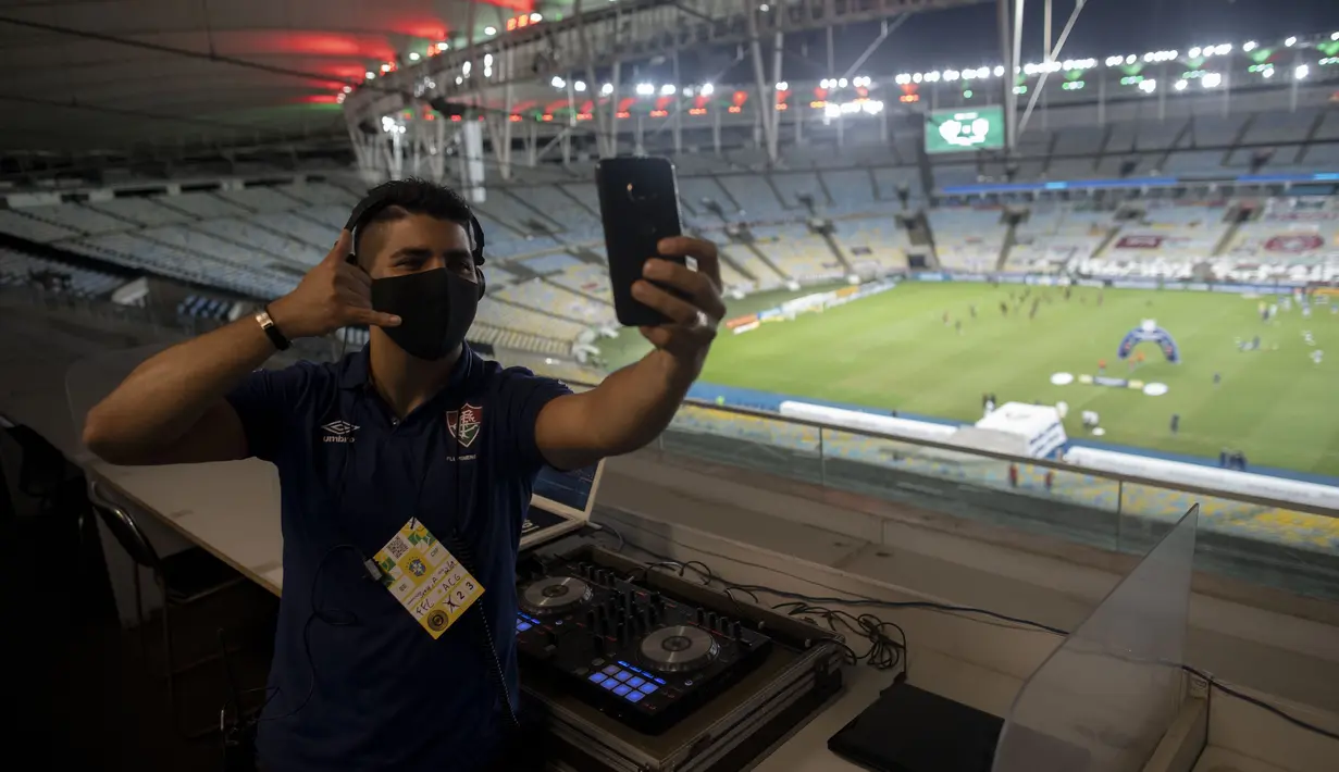 DJ Franklin Scheleger (29) berswafoto sebelum memainkan suara dan lagu menyerupai gemuruh suporter selama pertandingan antara Fluminense dan Atletico Goianiense dalam babak lanjutan Kejuaraan Brasil di Stadion Maracana, Rio de Janeiro, Brasil, pada 2 September 2020. (AFP/Mauro Pimentel)