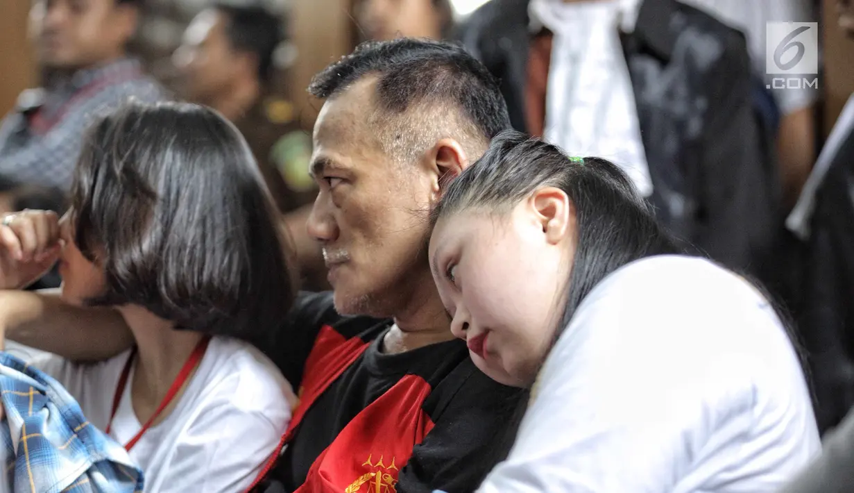 Aktor Tio Pakusadewo merangkul sang anak, Risa (kiri) dan keponakannya, Namira saat menunggu sidang  kasus penyalahgunaan narkoba di Pengadilan Negeri Jakarta Selatan, Kamis (28/6). Sidang beragenda pembacaan pledoi oleh Tio. (Liputan6.com/Faizal Fanani)