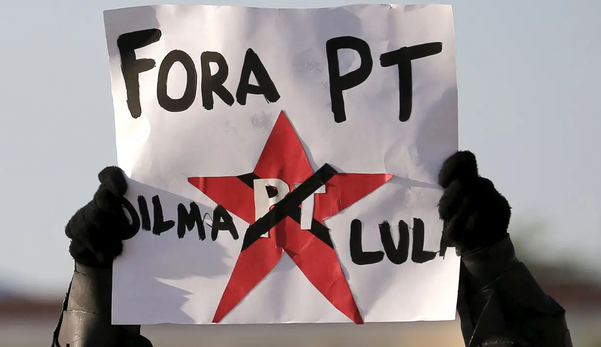 Pria berpakaian Batman membawa spanduk saat unjuk rasa mengecam skandal korupsi yang melanda para politisi dari partai Presiden Rousseff di Sao Paulo, Brasil, Minggu (16/08/2015). (REUTERS/Sergio Moraes)