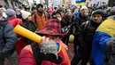 Demonstran anti-vaksin berunjuk rasa di Kiev (24/11/2021). Ratusan pengunjuk rasa memblokir jalan-jalan di pusat kota Kiev pada 24 November untuk berdemonstrasi menentang langkah-langkah anti-Covid Ukraina dan upaya vaksin, saat negara itu memerangi gelombang infeksi baru. (AFP/Genya Savilov)