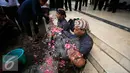 Soerang pengunjukrasa saat dimandikan kembang usai melakukan aksi teatrikal  manusia semen di depan Gedung DPRD DIY, (29/2). Mereka menuntut keseimbangan dalam fungsi dan kepemilikan ruang dengan masyarakat. (Liputan6.com/Boy Harjanto)