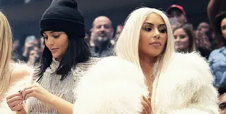Kim Kardashian hadir di acara Yeezy pada 2016 dengan pakaian terbuka di balik mantel berbulu sedangkan Kylie Jenner hadir dengan baju menerawang. (REX/Shutterstock/HollywoodLife)