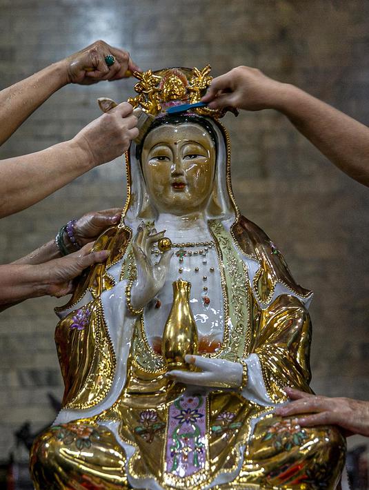 Para jemaat menyikat patung yang ada di Vihara Amurva Bhumi, Jakarta, Kamis (4/2/2021). Ritual mencuci patung dewa serta bersih-bersih ini dilakukan dalam rangka menyambut perayaan Tahun Baru Imlek 2572. (Liputan6.com/Faizal Fanani)