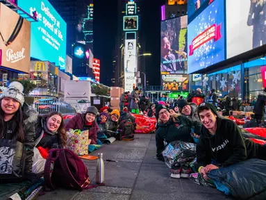 Orang-orang menghabiskan malam dengan tidur di area terbuka dalam acara World's Big Sleep Out di Times Square, New York, 7 Desember 2019. Aksi di beberapa kota besar dunia ini sebagai bagian dari upaya penggalangan dana untuk membantu para tunawisma di banyak negara. (Charles Sykes/Invision/AP)