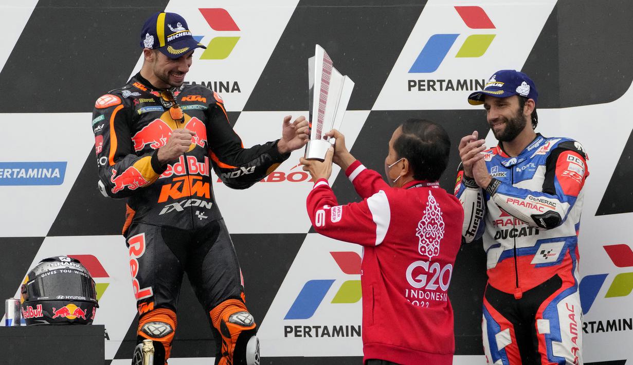 Miguel Oliveira dengan bangga menerima trofi juara MotoGP Mandalika 2022 dari Presiden RI Joko Widodo. (AP/Achmad Ibrahim)