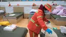 Pekerja memasang selimut listrik di rumah sakit sementara yang sebelumnya merupakan gedung olahraga Wuhan Sports Center di Wuhan, Provinsi Hubei, China tengah (12/2/2020). Rumah sakit sementara yang memiliki total 1.100 ranjang tersebut siap menerima pasien coronavirus baru. (Xinhua/Xiao Yijiu)