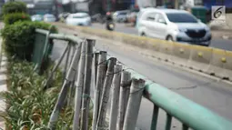 Kondisi pagar pembatas jalur transjakarta yang ditopang bambu di Jalan Otista Raya, Jakarta, Jumat (5/7/2019). Meskipun telah lama rusak, pagar besi berjeruji yang berfungsi sebagai pembatas agar orang tidak menyeberang secara sembarangan itu belum juga diperbaiki. (Liputan6.com/Immanuel Antonius)