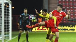Gelandang Borusia Dortmund, Jude Bellingham, berebut bola dengan bek Union Berlin, Robin Knoche, pada laga lanjutan Liga Jerman di Stadion Alte Forsterei, Sabtu (19/12/2020) dini hari WIB. Borussia Dortmund kalah 1-2 melawan Union Berlin. (AFP/Annegret Hilse/pool)