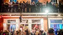 Warga melihat para demonstran yang sedang melakukan aksi di Bourbon Street, New Orleans (1/2). Sebelumnya delapan klub di New Orleans telah ditutup karena pelanggaran prostitusi dan narkoba. (AFP/Emily Kask)